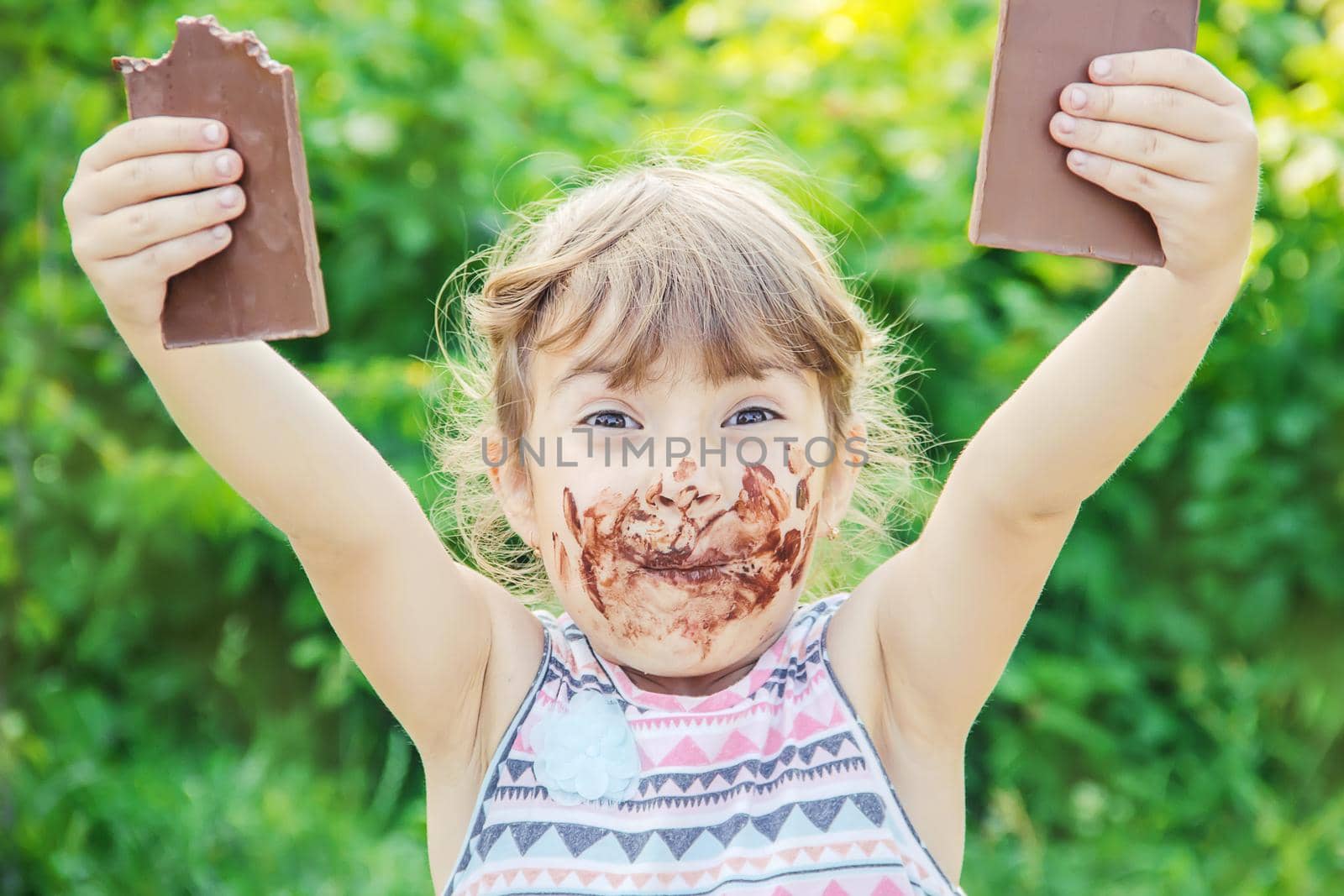 A sweet-toothed child eats chocolate. Selective focus.