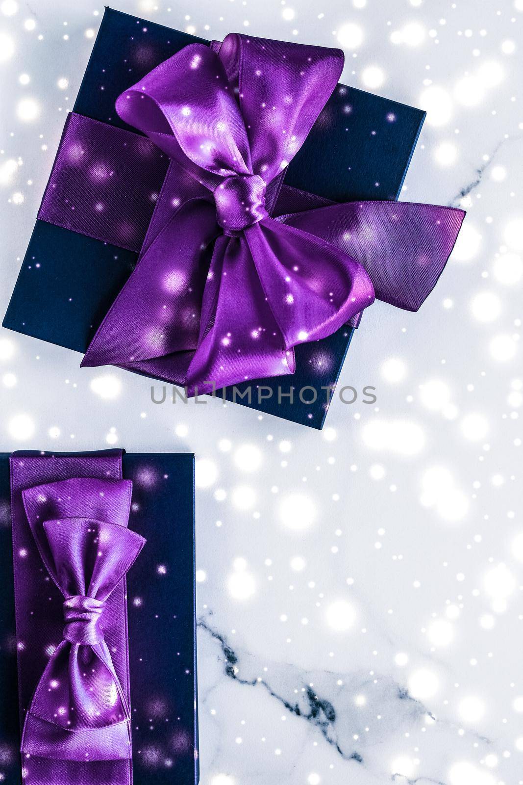 Branding, glamour and cold season concept - Winter holiday gift box with purple silk bow, snow glitter on marble background as Christmas and New Years presents for luxury beauty brand, flatlay design