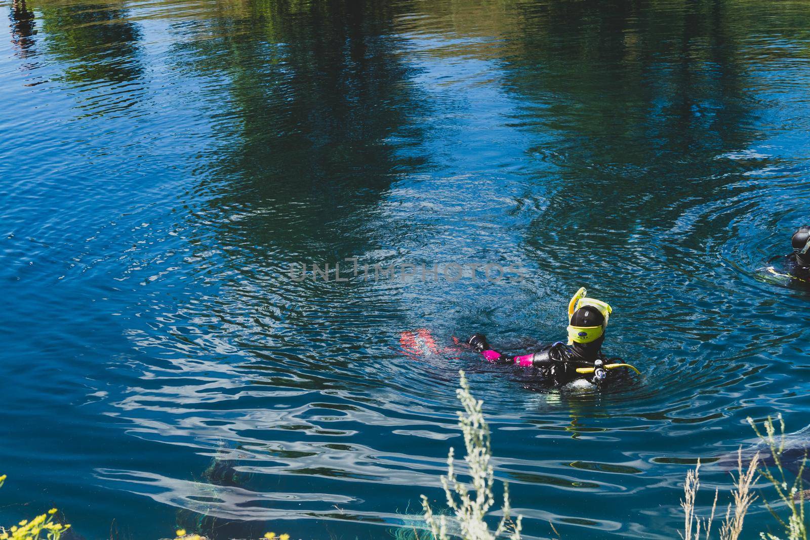 Divers in water. Study of river bottom. Search for missing people. by Verrone