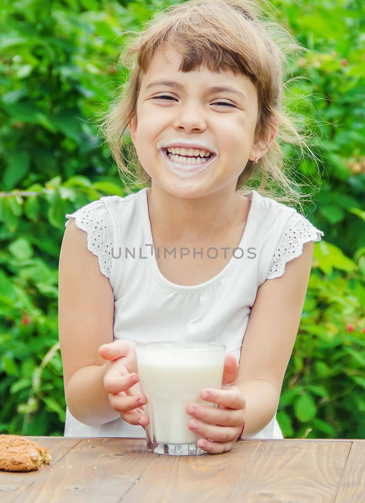 The child drinks milk and cookies. Selective focus. by yanadjana