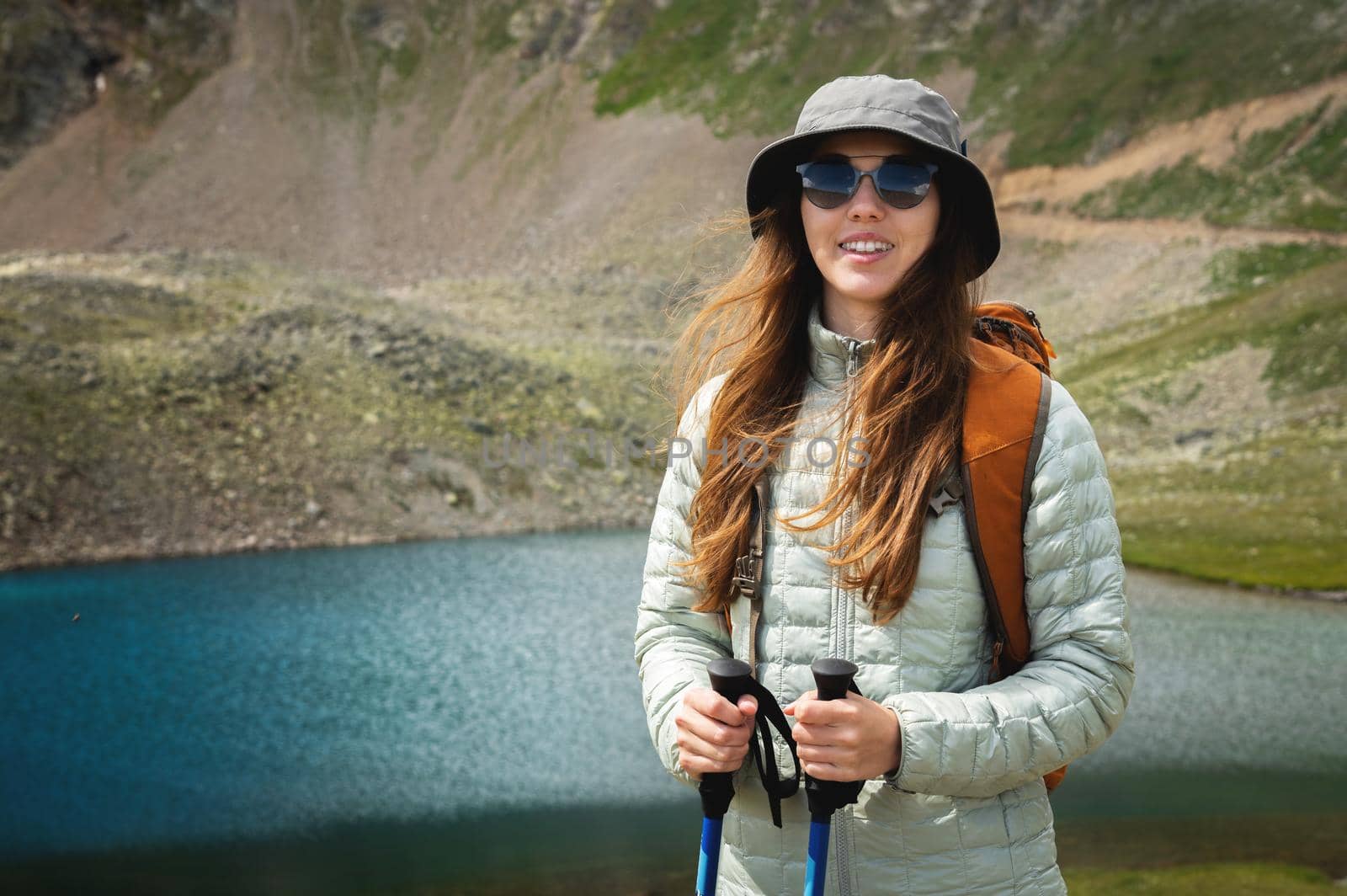female tourist enjoys the view of mountain peak rock and lake. idea of ecotourism. Travel concept.