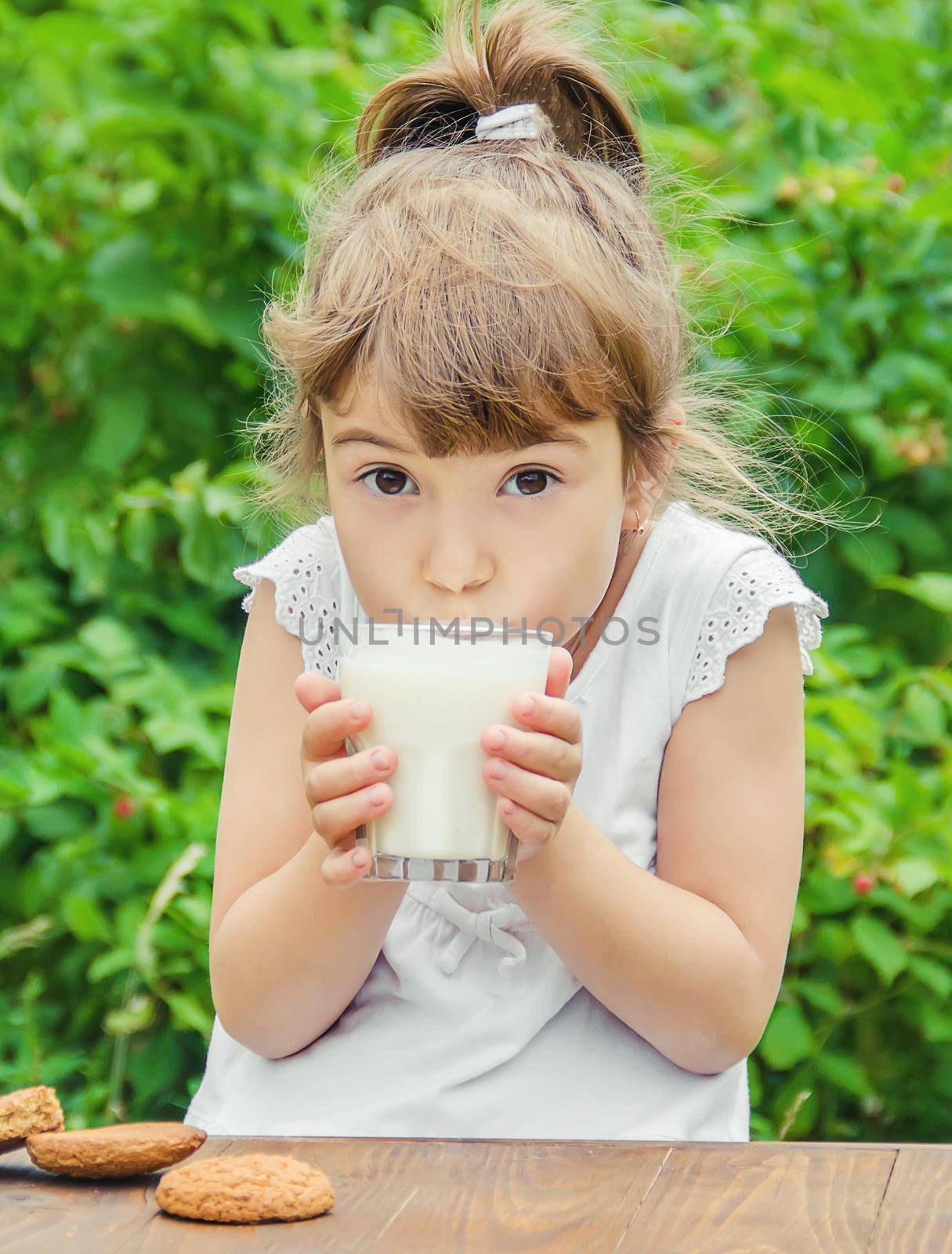 The child drinks milk and cookies. Selective focus. by yanadjana