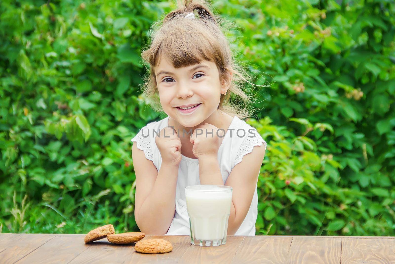 The child drinks milk and cookies. Selective focus.