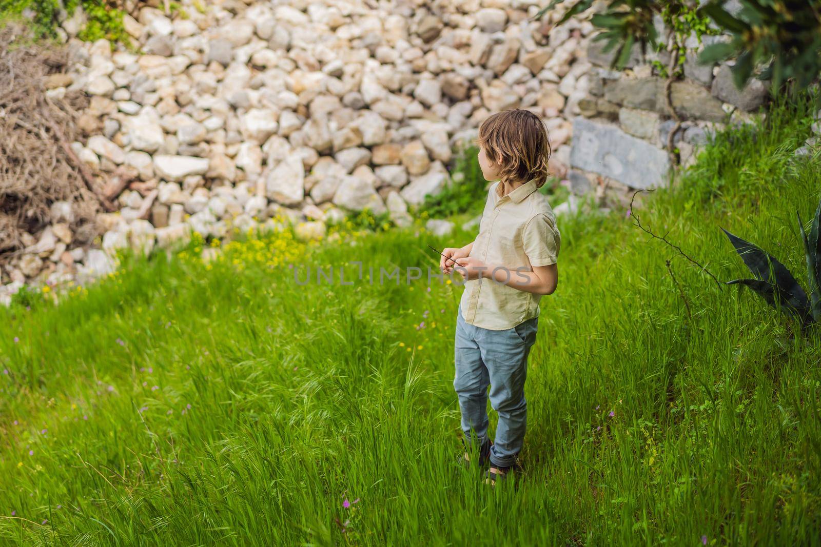 Boy tourist walks through the old town of Bar in Montenegro. Happy tourist walks in the mountains. Suburbs of the city of Bar, Montenegro, Balkans. Beautiful nature and landscape by galitskaya