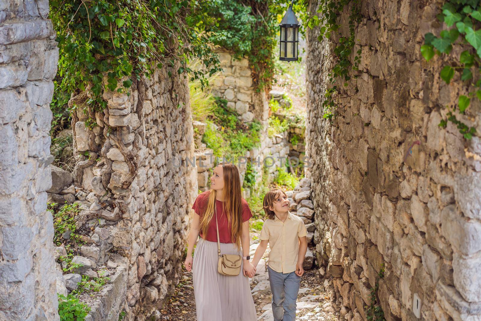 Mom and son tourists walks through the old town of Bar in Montenegro. Happy tourist walks in the mountains. Suburbs of the city of Bar, Montenegro, Balkans. Beautiful nature and landscape.