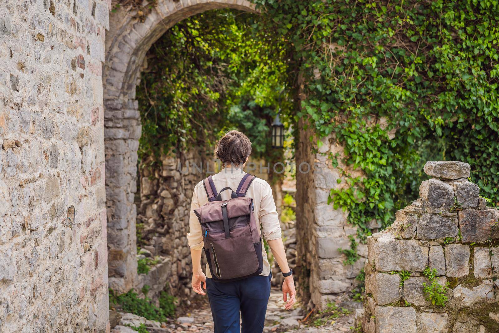 Man tourist walks through the old town of Bar in Montenegro. Happy tourist walks in the mountains. Suburbs of the city of Bar, Montenegro, Balkans. Beautiful nature and landscape.