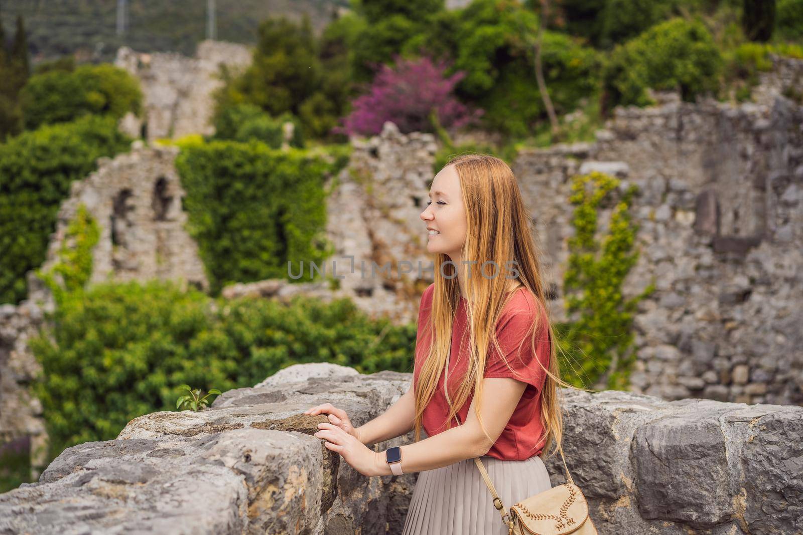 Woman tourist walks through the old town of Bar in Montenegro. Happy tourist walks in the mountains. Suburbs of the city of Bar, Montenegro, Balkans. Beautiful nature and landscape.