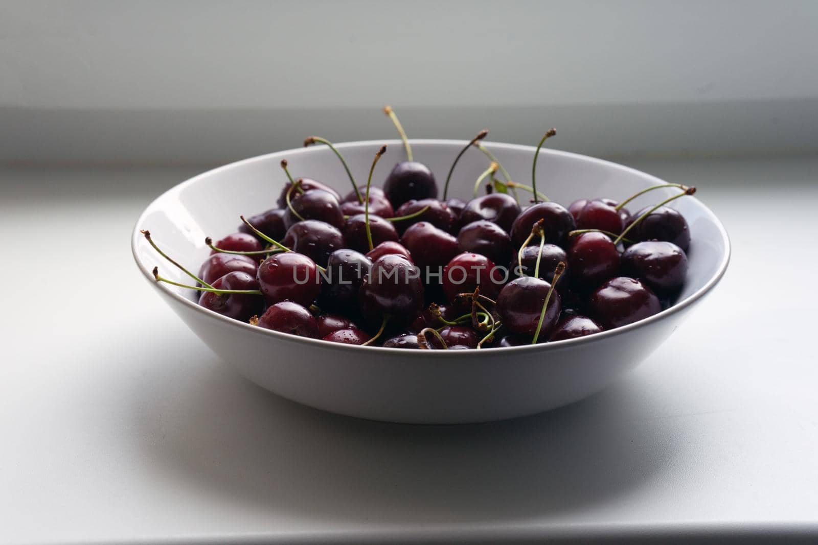 Large white glass plate full of cherries. High quality photo