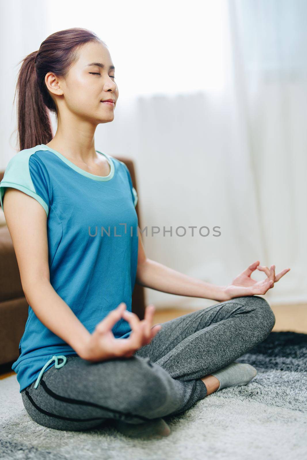 stress relief, muscle relaxation, breathing exercises, exercise, meditation, portrait of Young Asian woman relaxing her body from office work by practicing yoga by watching online tutorials.