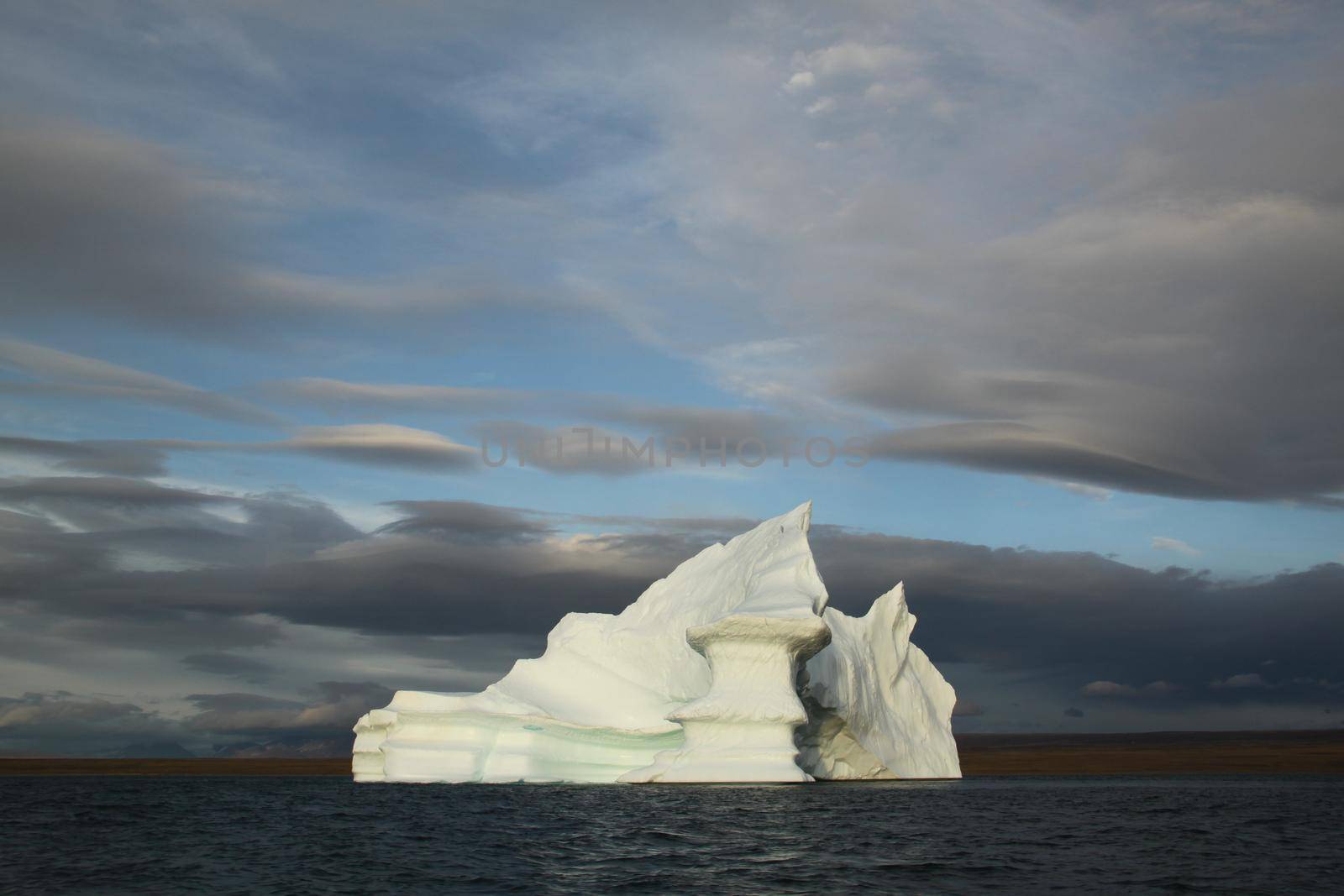 Stranded tabular iceberg and ice near evening in arctic landscape, near Pond Inlet, Nunavut, Canada