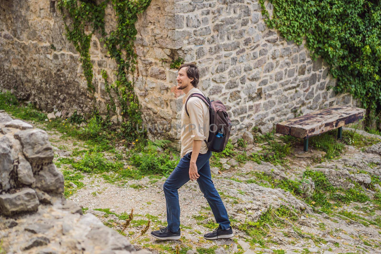 Man tourist walks through the old town of Bar in Montenegro. Happy tourist walks in the mountains. Suburbs of the city of Bar, Montenegro, Balkans. Beautiful nature and landscape.