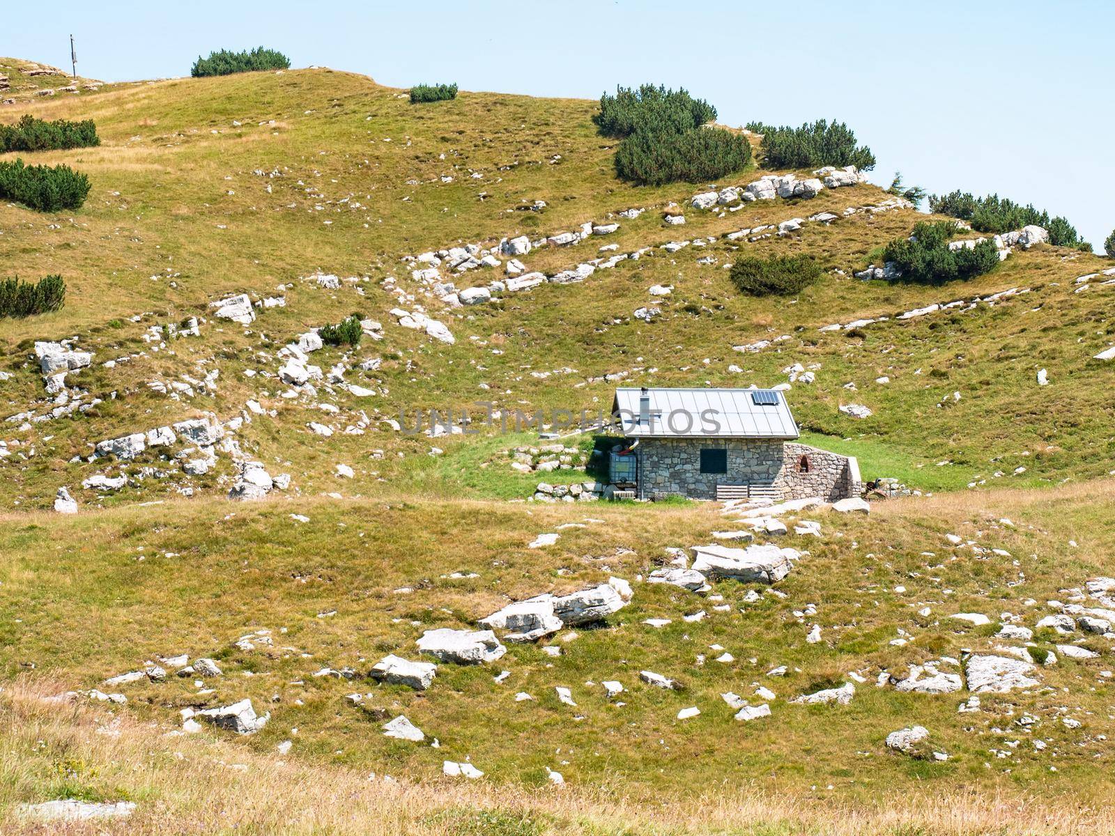 Stony holiday cottage hidden in meadow close to peak of Canfedin mountain 1865 metres high. Vezzano region, Trentino, Italy