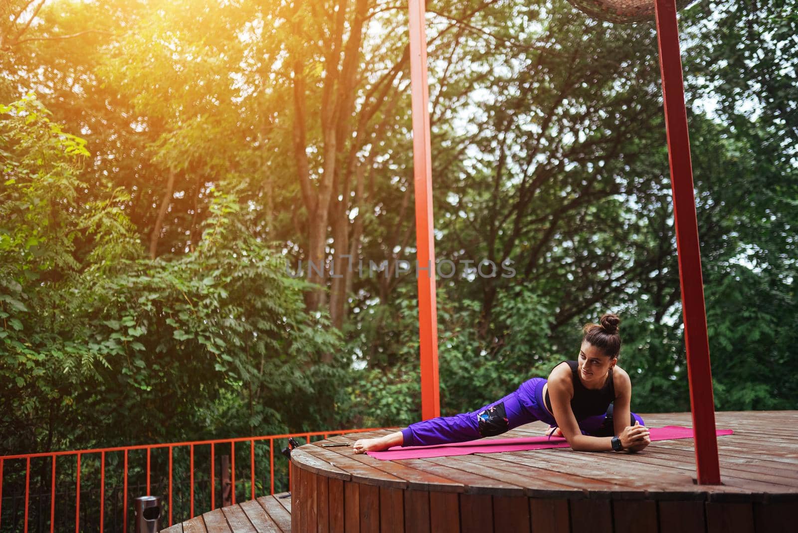 A young woman in doing yoga in the yard on the veranda