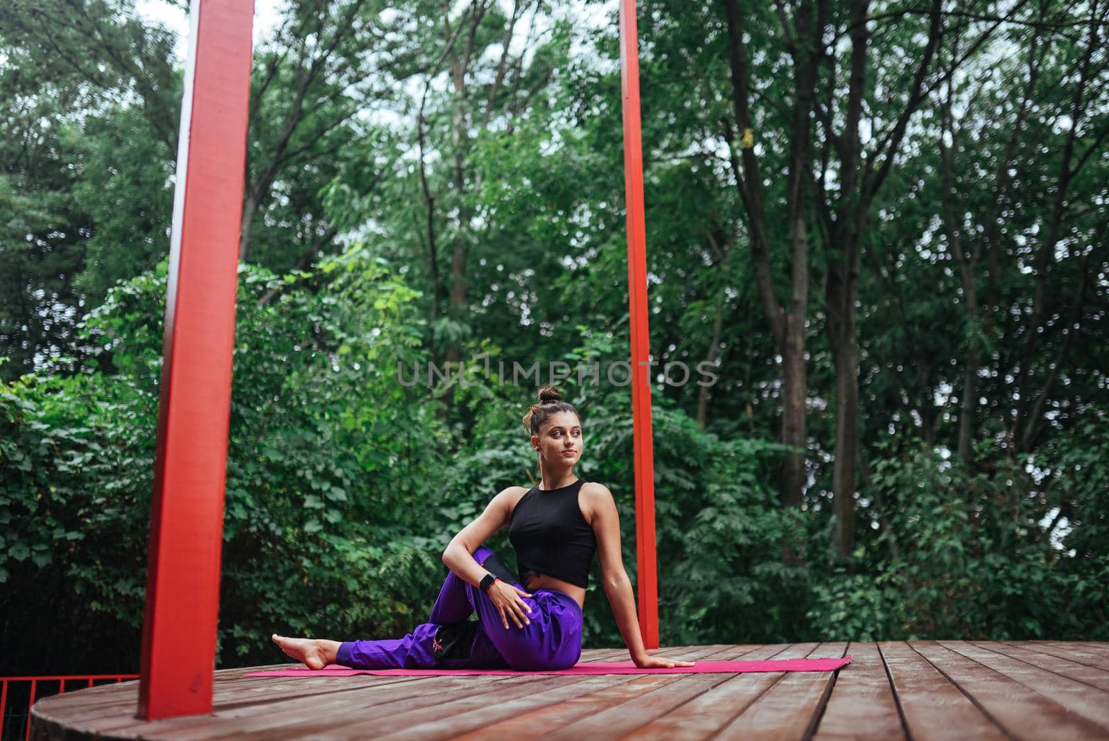 A young woman in doing yoga in the yard on the veranda