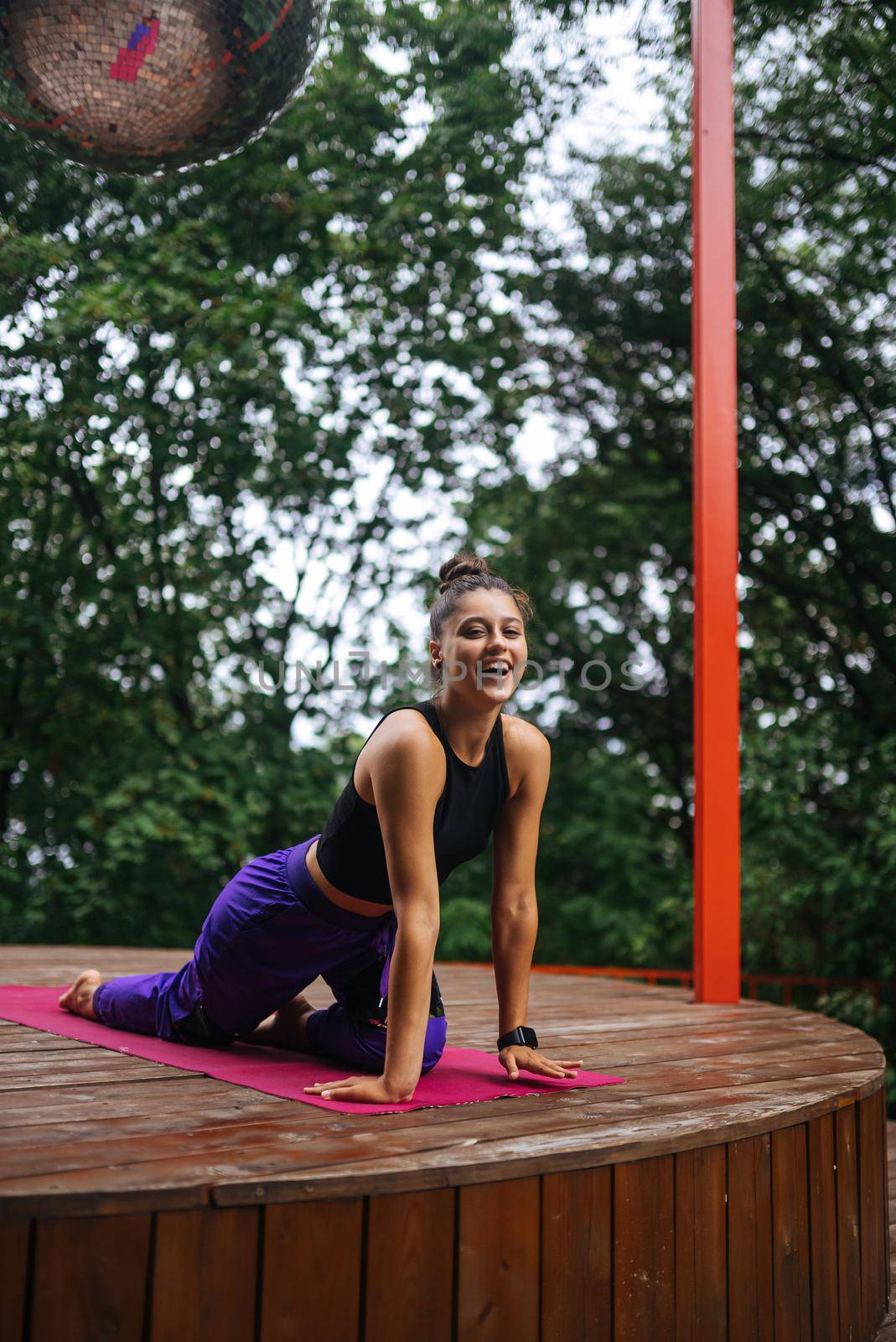 A young woman in doing yoga in the yard on the veranda