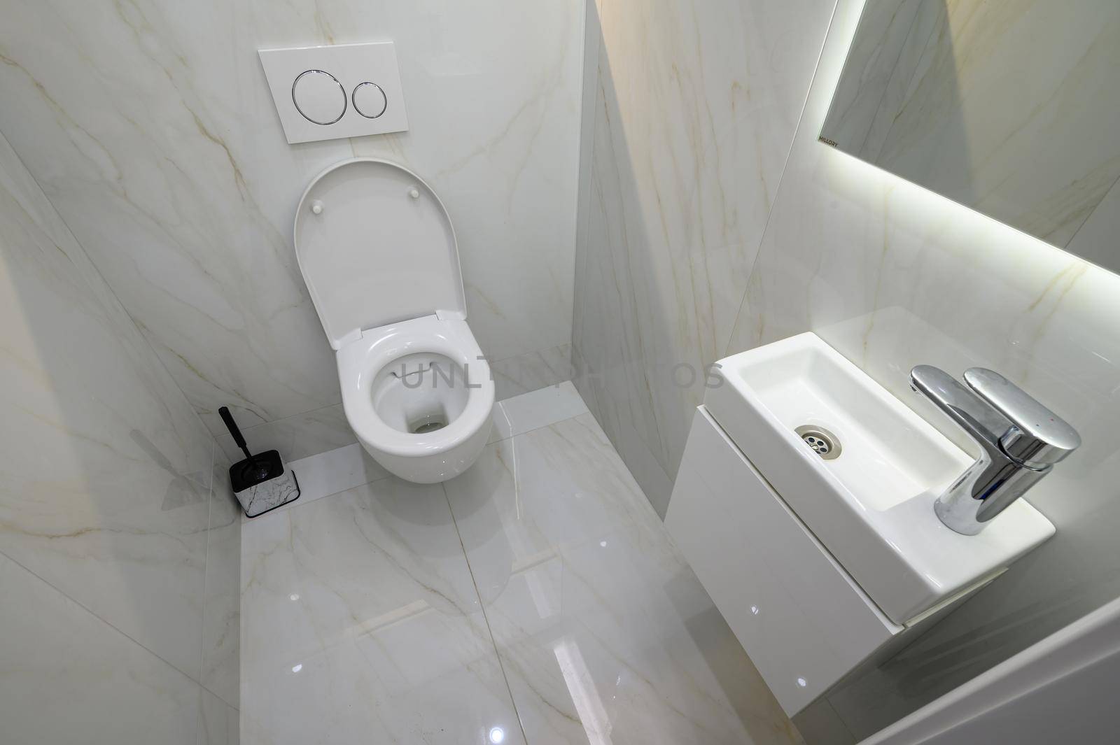 Small toilet bathroom interior with hand wash sink and toilet bowl