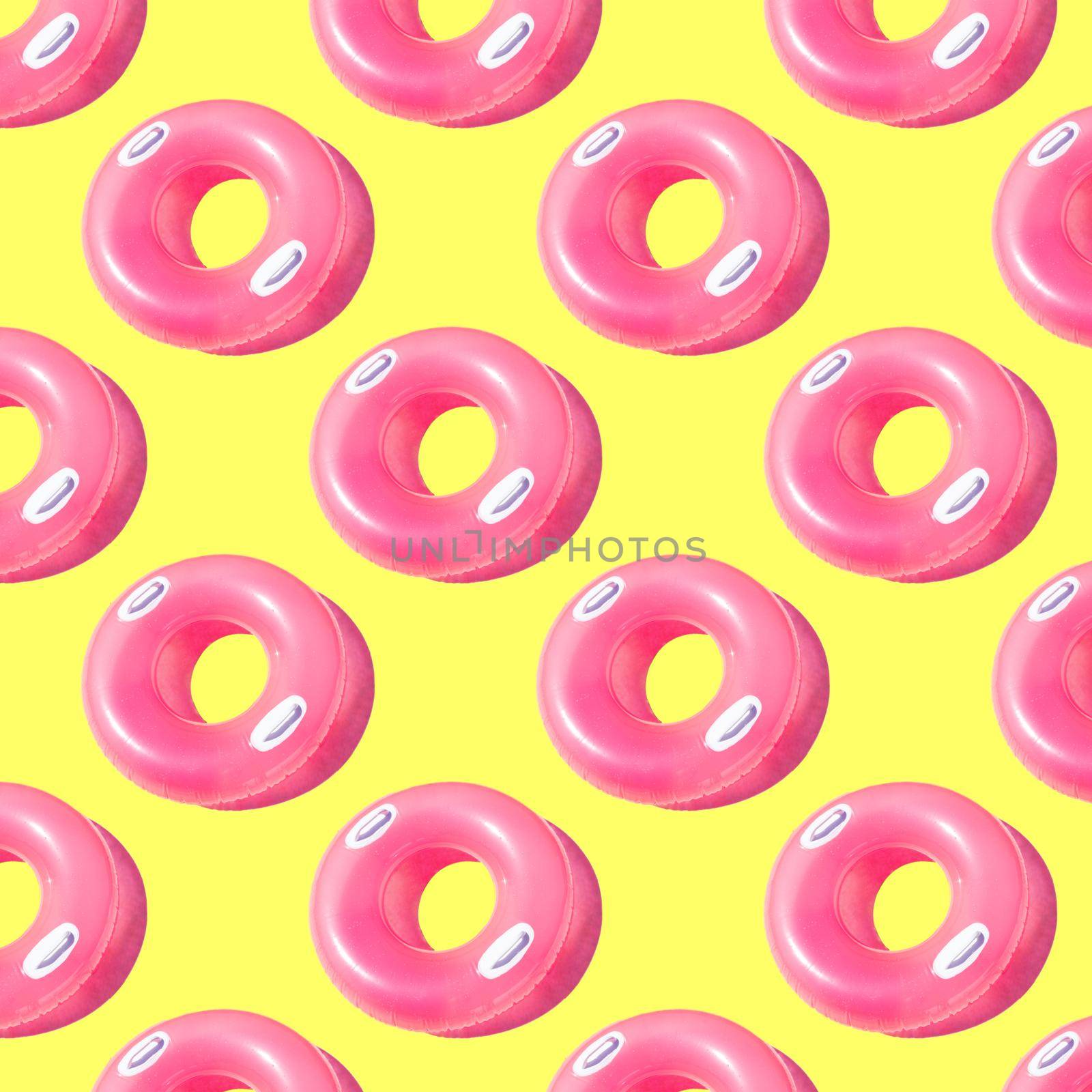 Bright pink inflatable circle with white handles and a shadow on a yellow background pattern