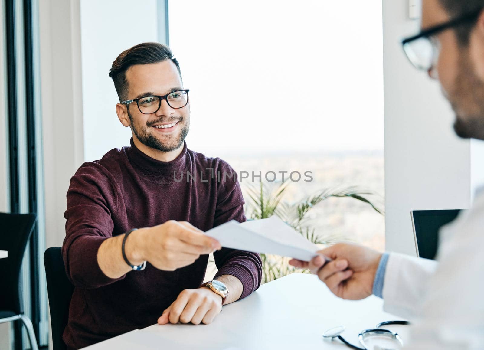 portrait of a young man holding papers or contract during a meeting in the office ot patient with doctor in hoispital