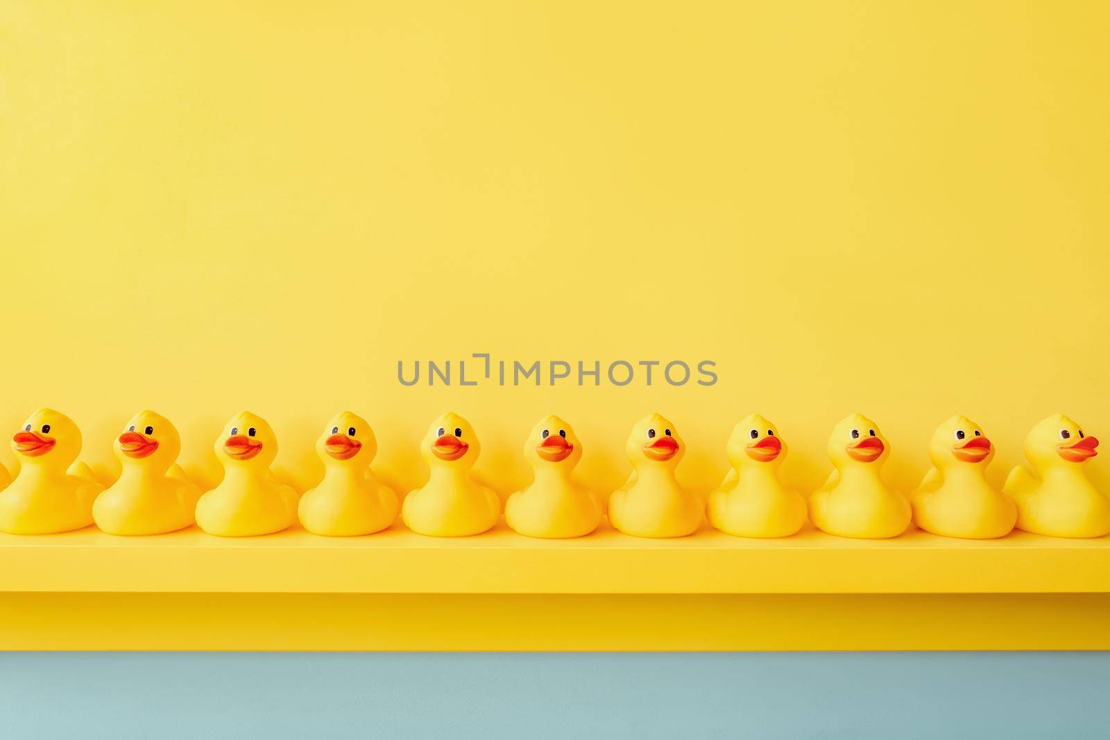 Yellow rubber duck in a line toy design yellow concept team work together. Rubber ducky bath toy background yellow ducks in a row. Rubber duck background team meeting. Community. Teamwork. Cooperation by synel