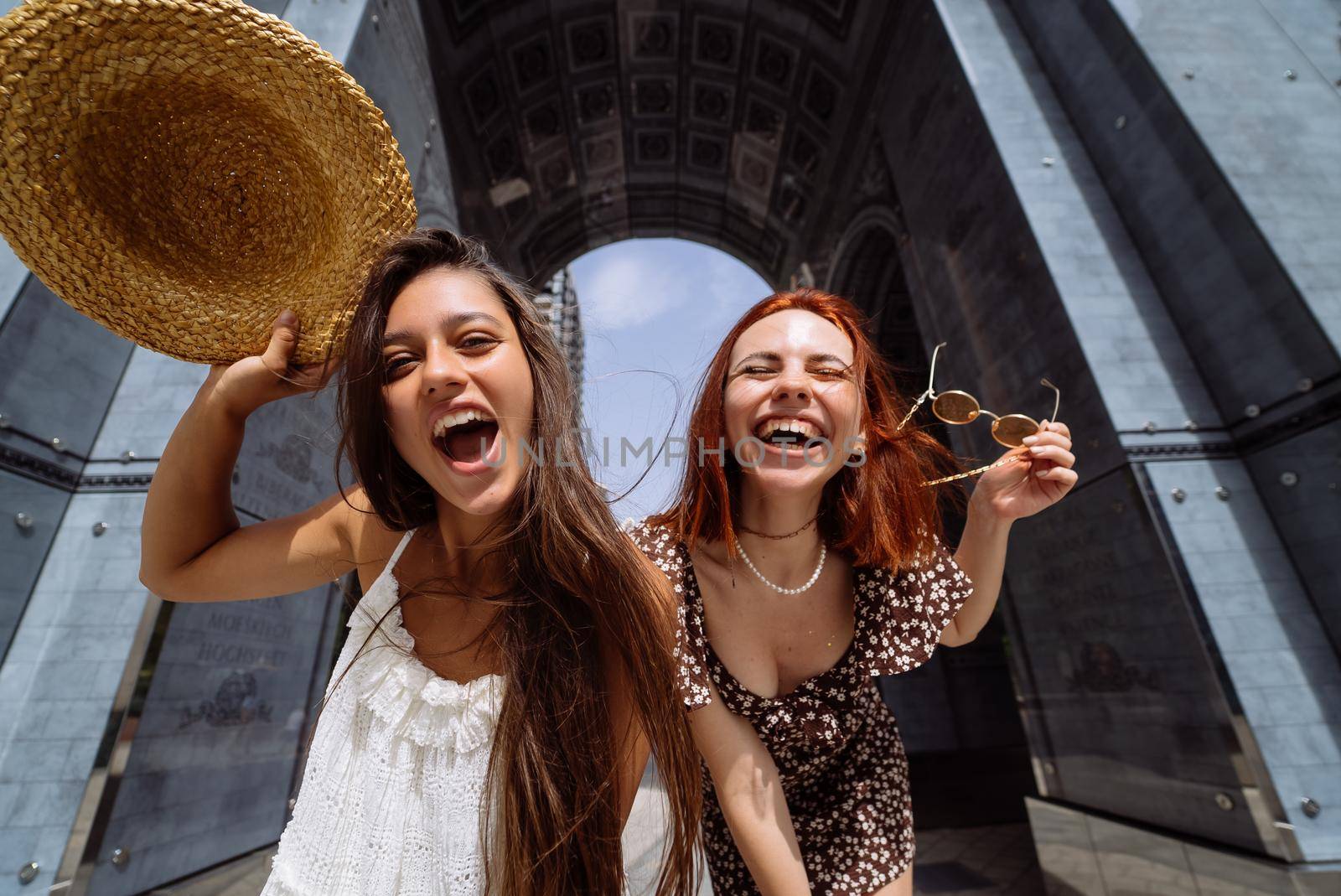 Portrait of two young beautiful smiling hipster female in trendy summer clothes.Sexy carefree women posing on street background.