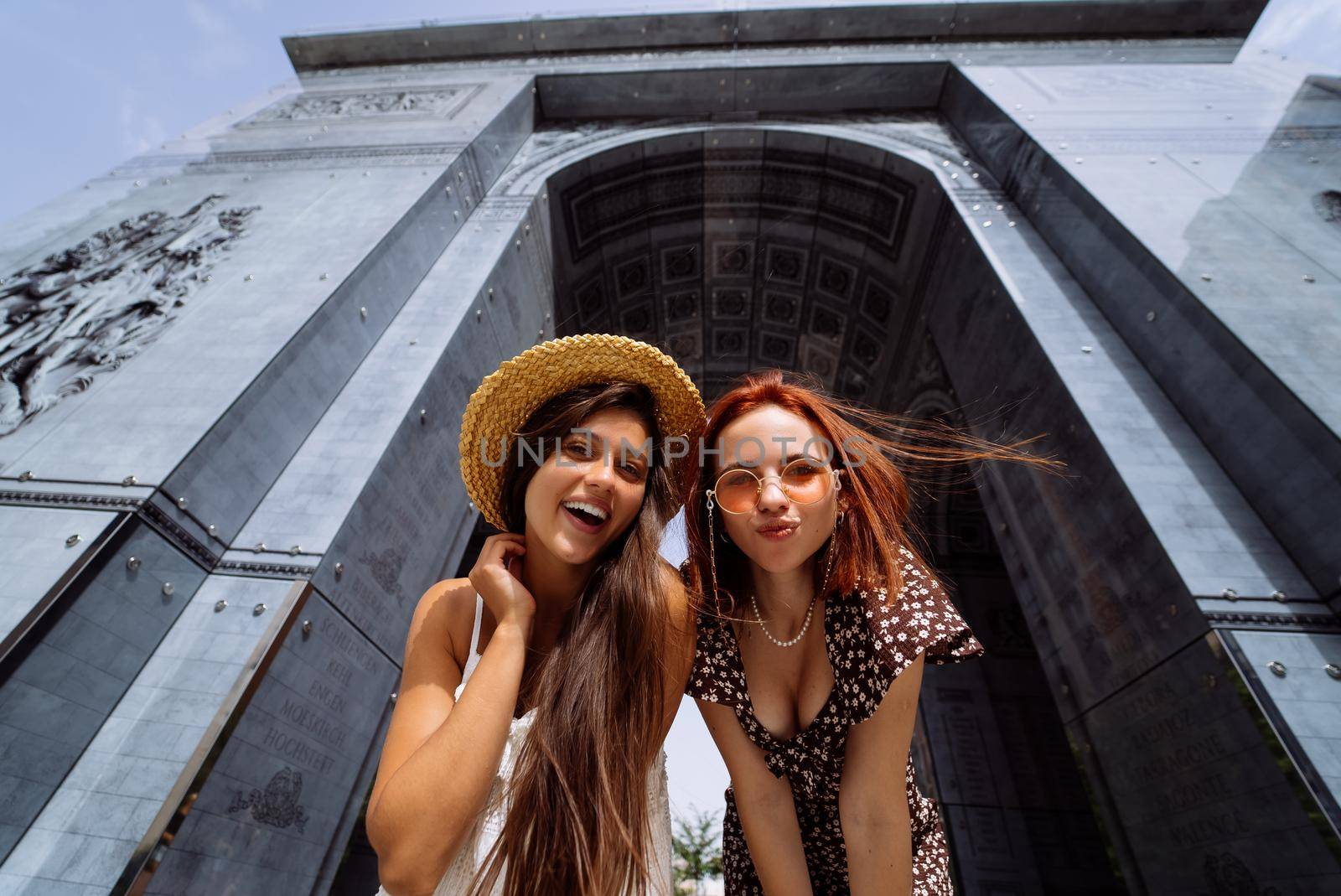 Portrait of two young beautiful smiling hipster female in trendy summer clothes.Sexy carefree women posing on street background.