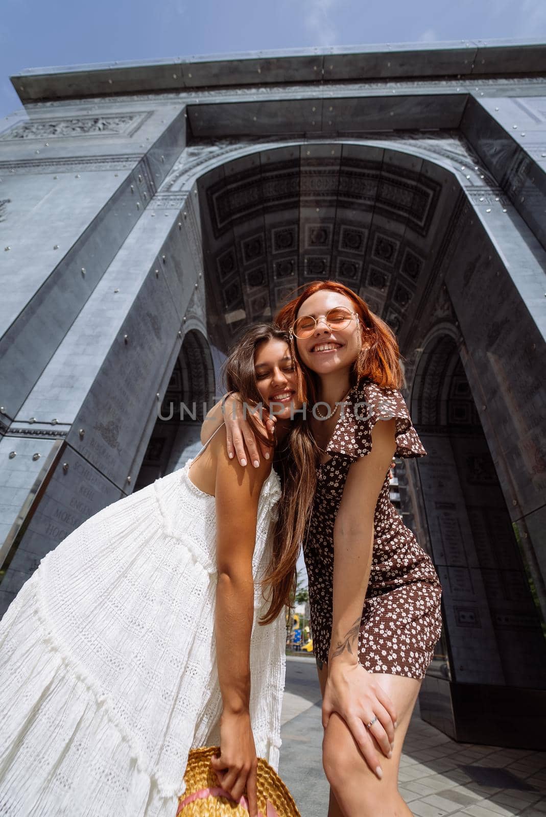 Portrait of two young beautiful smiling hipster female in trendy summer clothes.Sexy carefree women posing on street background.