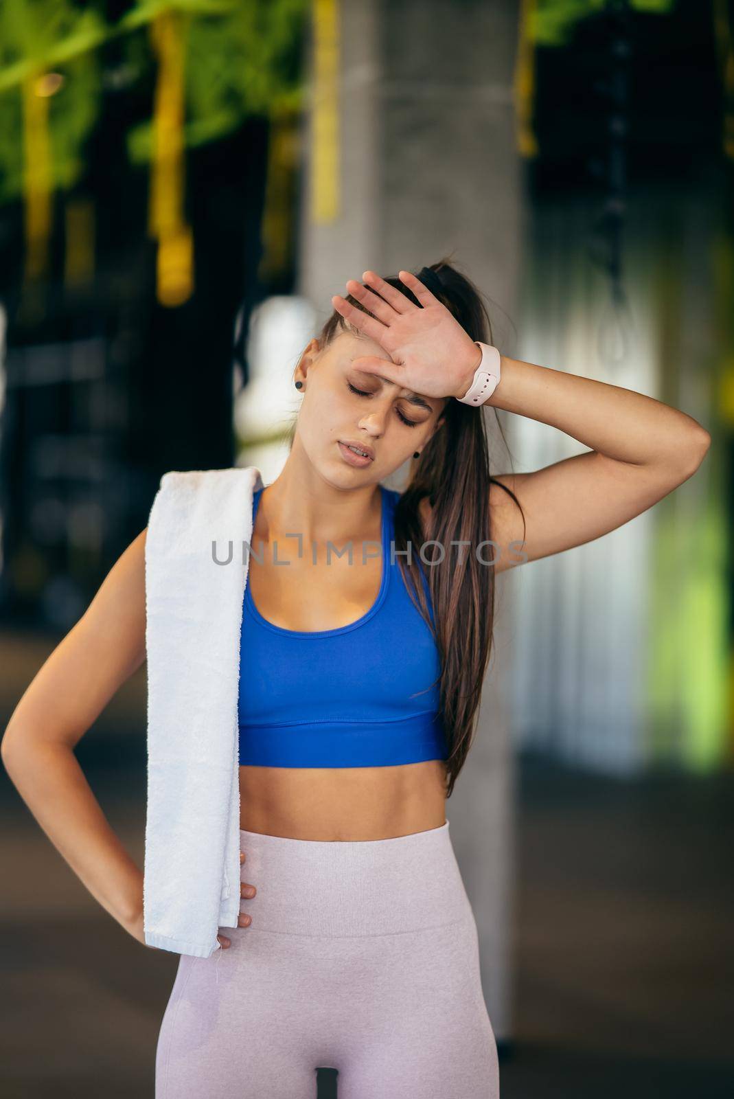 Healthy young female relaxed after training in gym. Woman resting after workout at gym.
