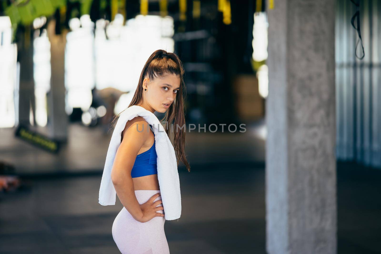 Healthy young female relaxed after training in gym. Woman resting after workout at gym.