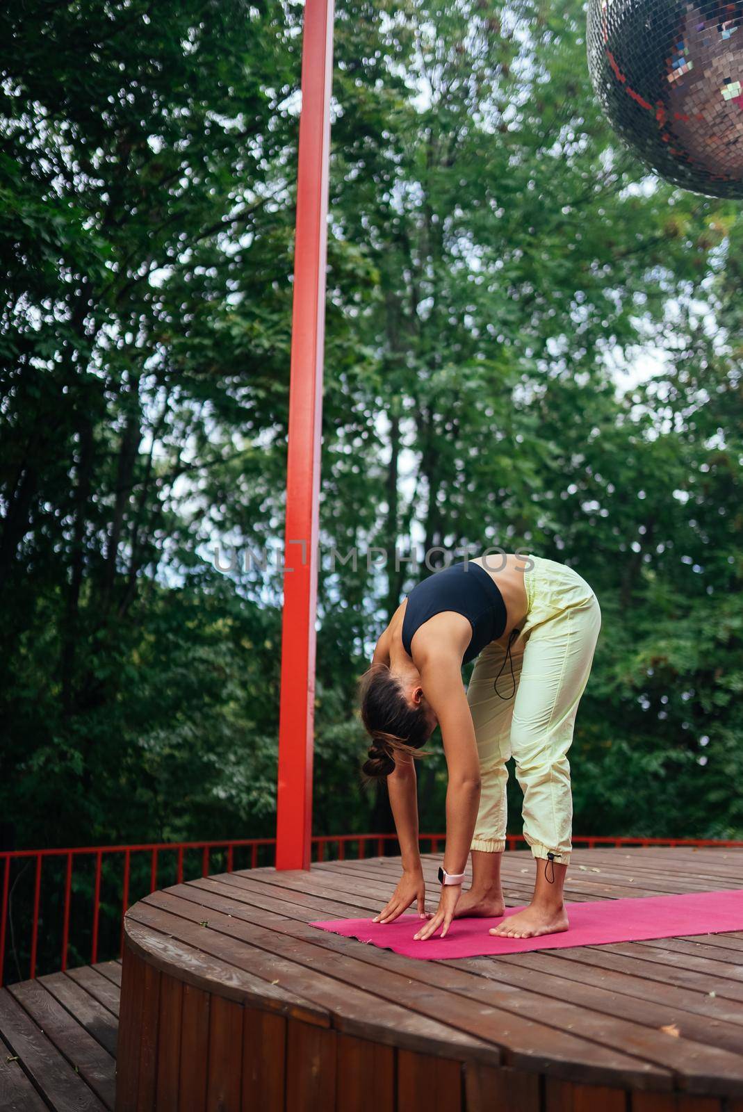 A young woman in doing yoga in the yard on the veranda