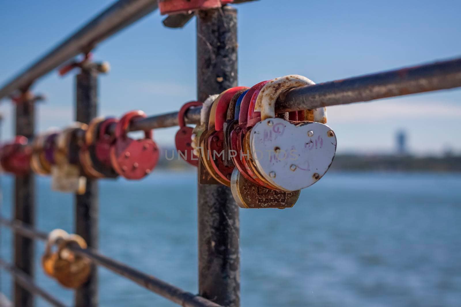 A heart-shaped door lock, a symbol of love and fidelity with a lake in the background, hangs on the fence of the bridge. The heart-shaped castle symbolizes loyalty and love.