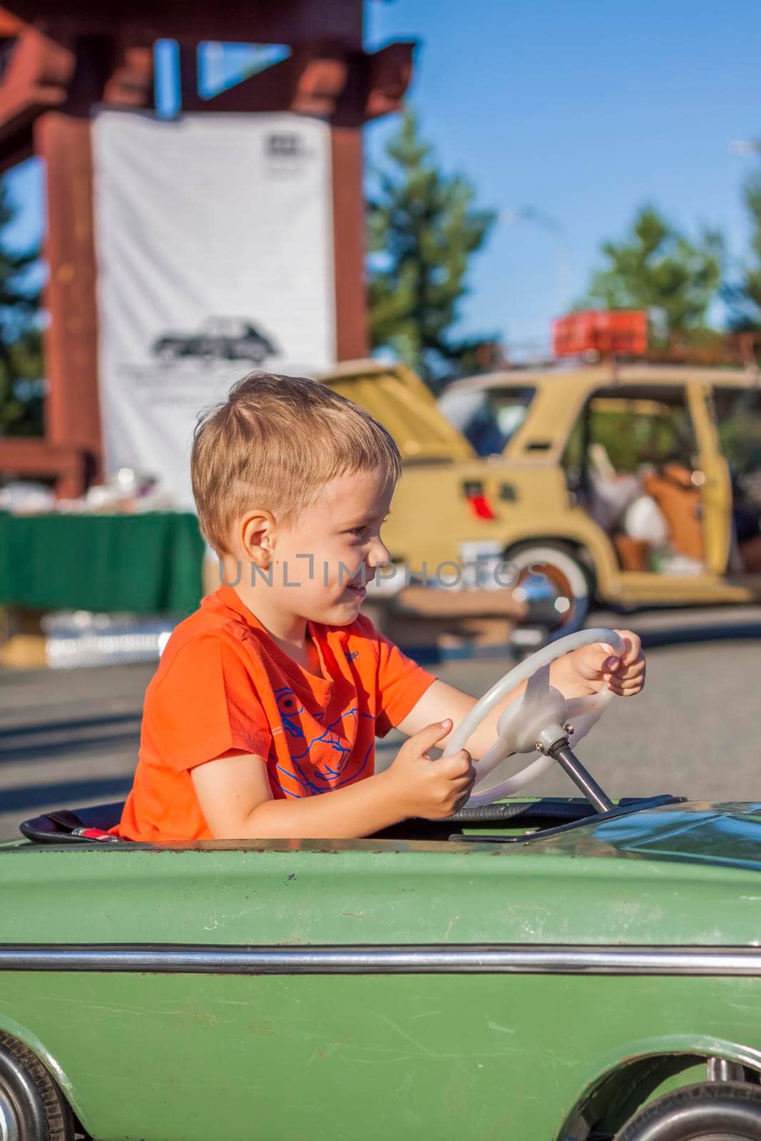 A boy driving a children's car. Joyful emotions. Children, portrait