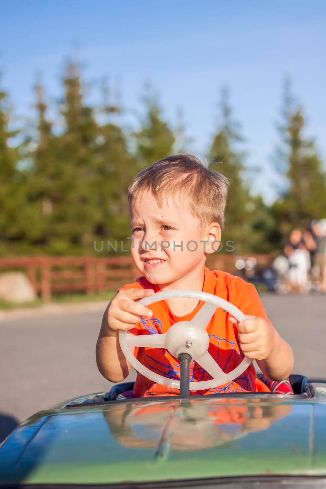 A boy driving a children's car. Joyful emotions. Children, portrait