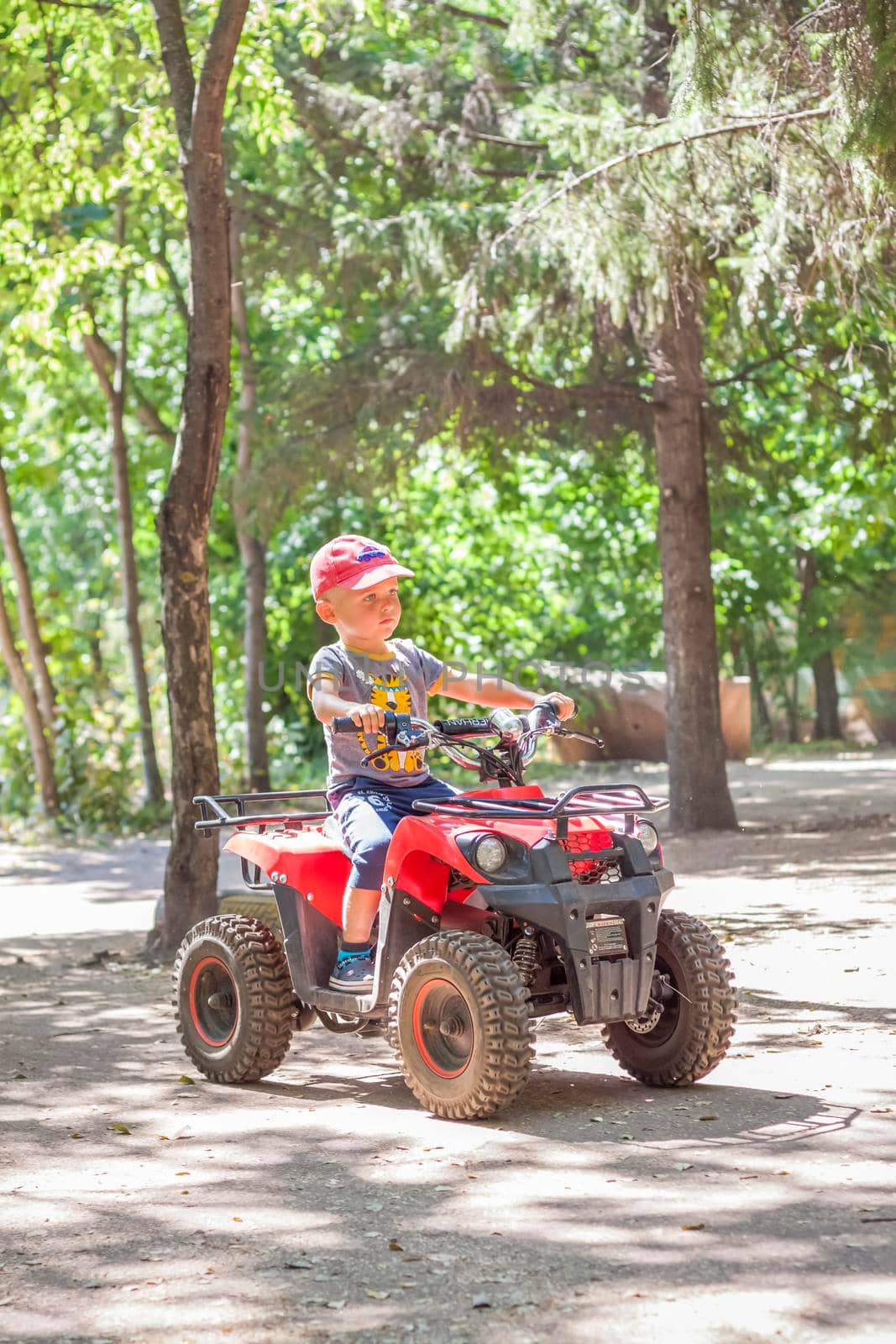 2022-08-16 Russia. Togliatti. Entertainment park. Little boys compete on children's ATVs and cars. A fun pastime. Natural images with natural emotions. Childhood