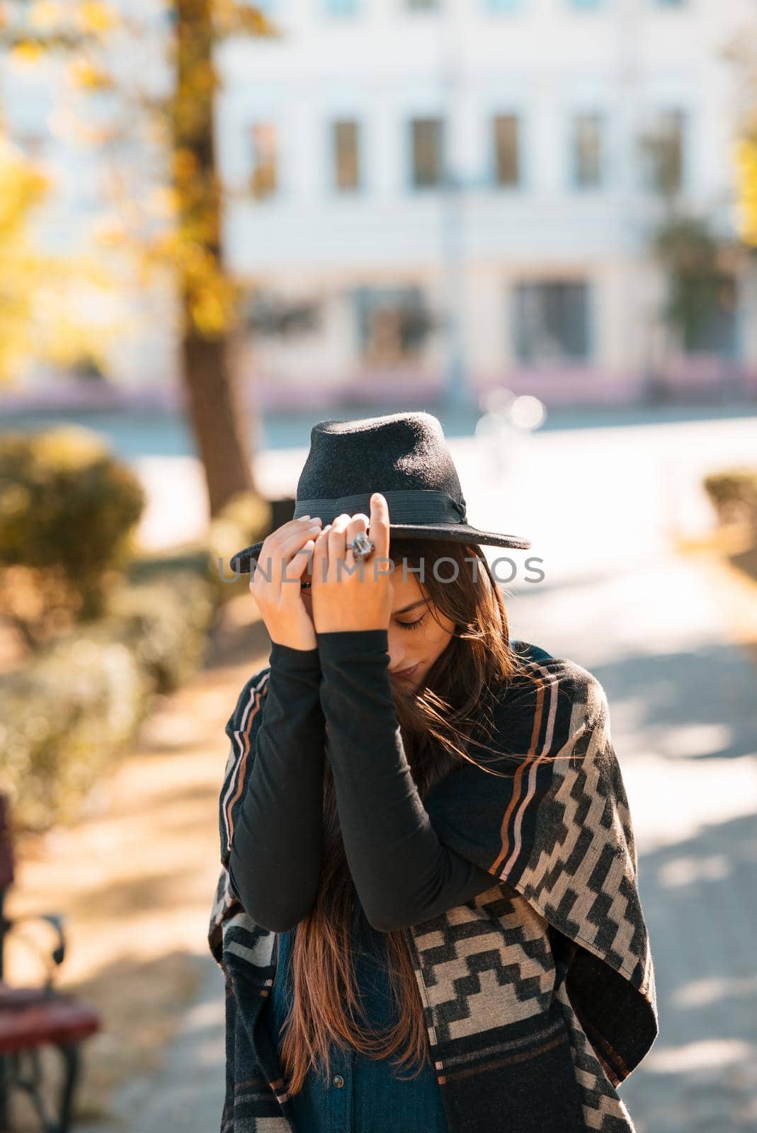 Stylish woman in poncho and hat enjoys autumn nature. People, freedom, lifestyle, travel and vacations concept.