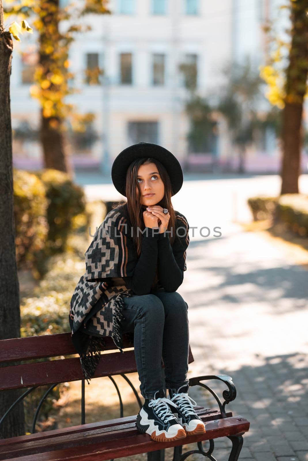 Young woman on a bench in the autumn park. People, freedom, lifestyle, travel and vacations concept.