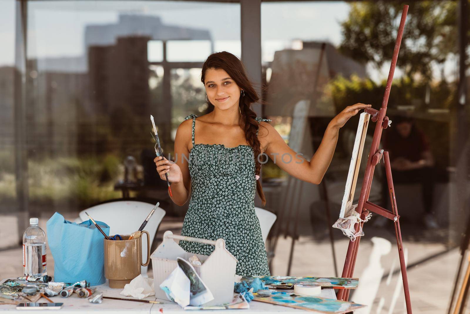 Young female artist with tools posing for camera