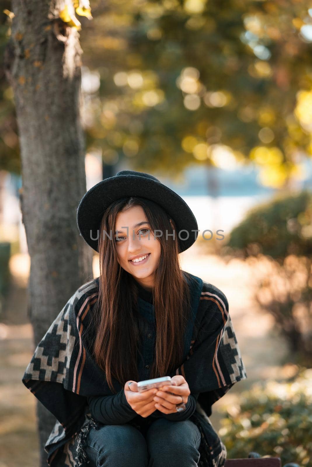 Young woman on a bench in the autumn park. People, freedom, lifestyle, travel and vacations concept.