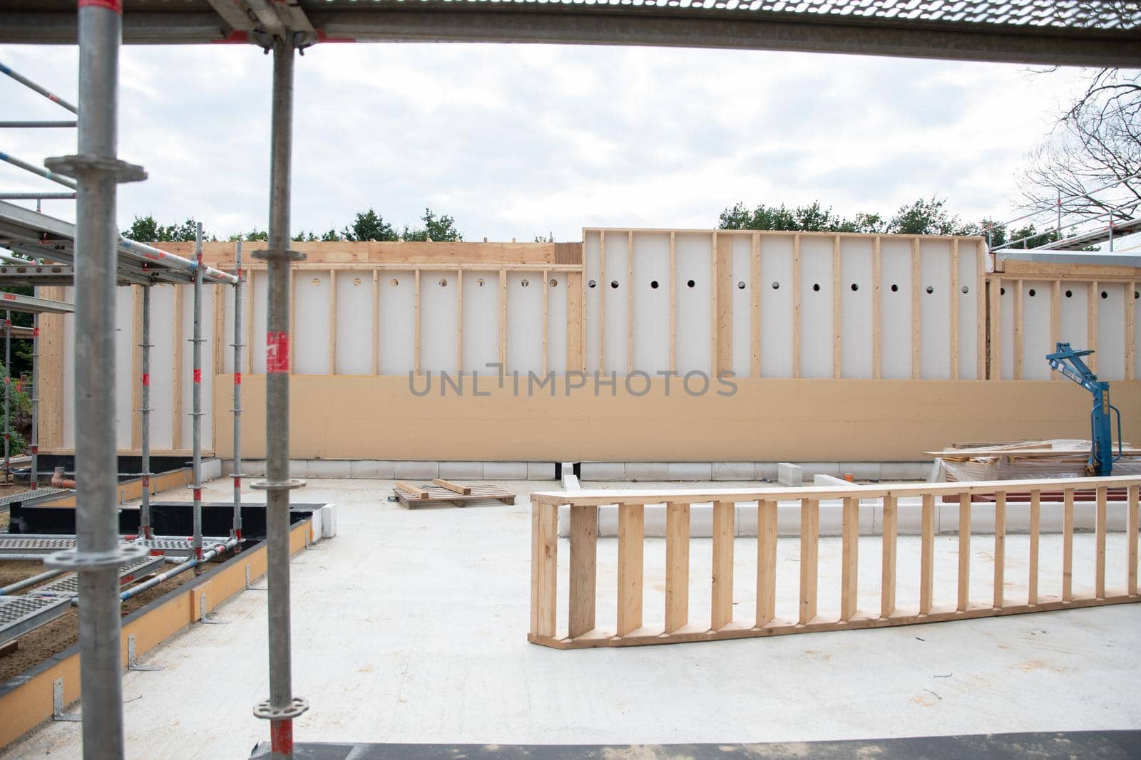 strong metal scaffolding at the construction site of a new house, the beginning of wooden structures around a metal frame. High quality photo