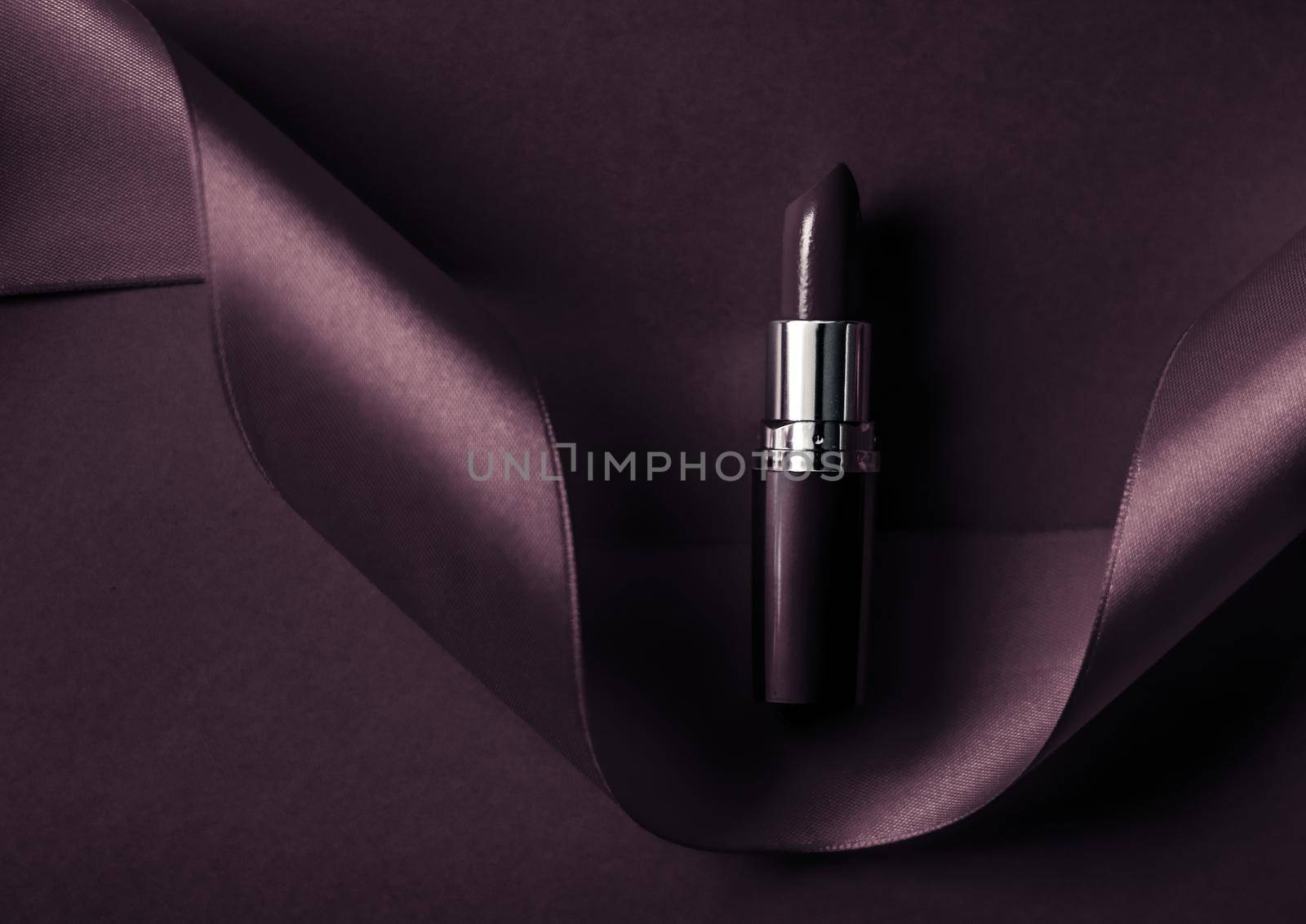 Cosmetic branding, glamour lip gloss and shopping sale concept - Luxury lipstick and silk ribbon on dark purple holiday background, make-up and cosmetics flatlay for beauty brand product design