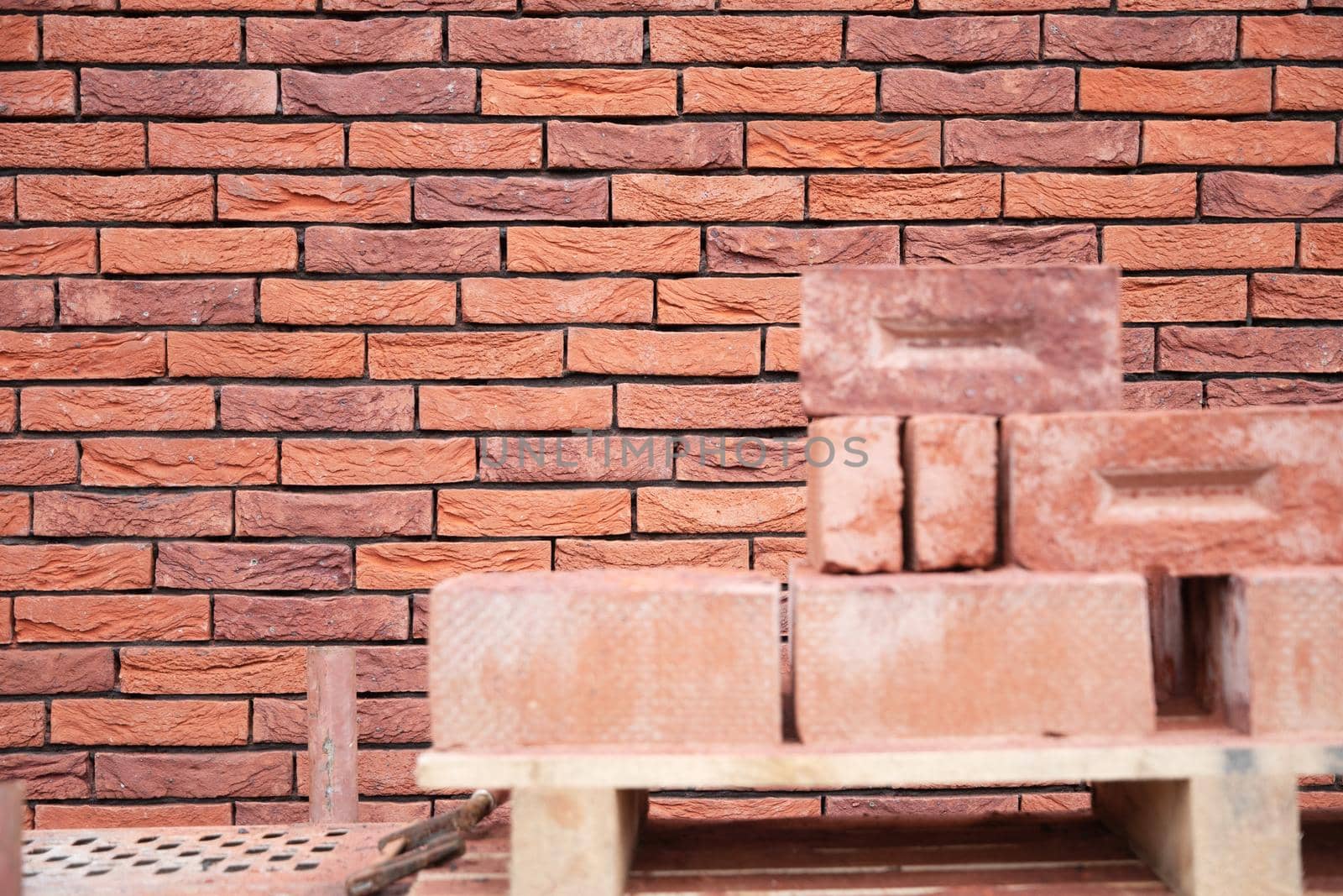 a new House is being built, the beginning of brickwork with red bricks, building materials, a pattern of stones, a natural background. High quality photo