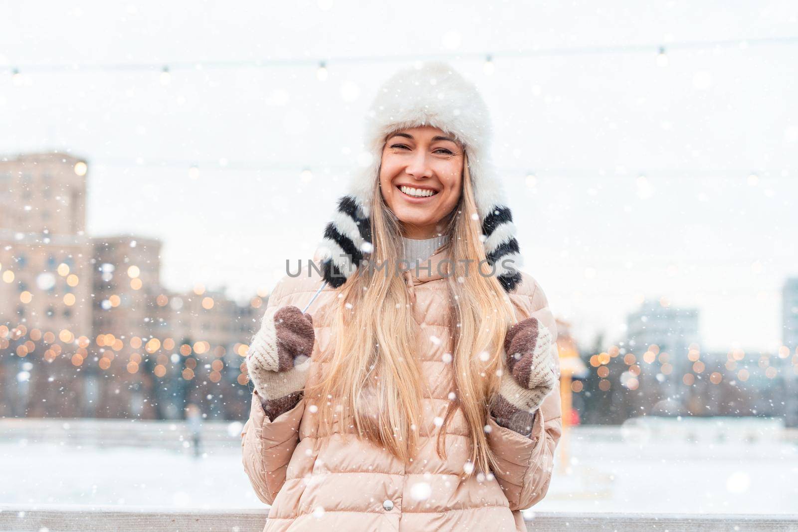 Happy winter time in big city charming girl standing street dressed funny fluffy hat. Enjoying snowfall, expressing positivity, smiling to camera, joyful cheerful mood, true emotions, Christmas mood