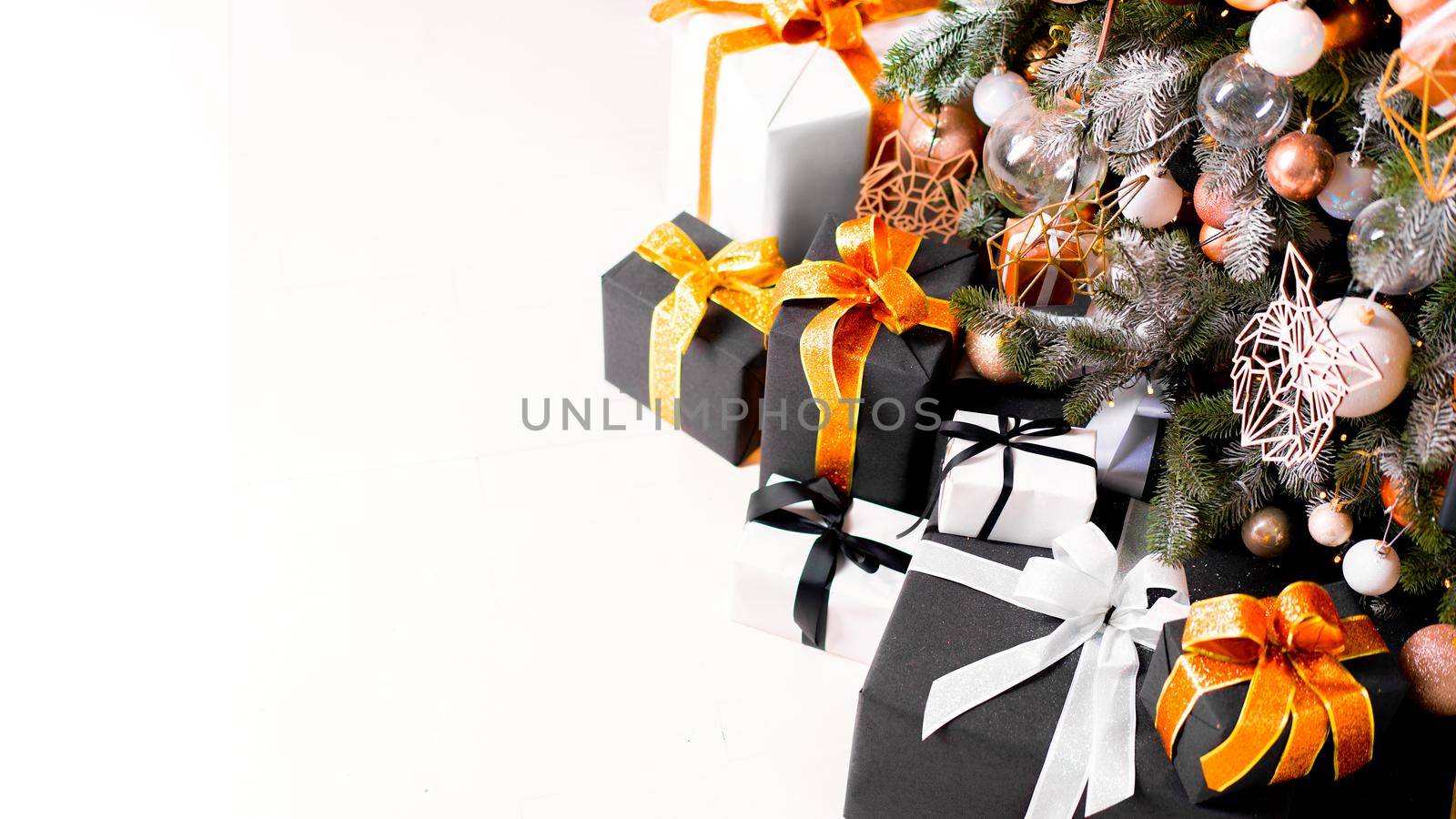 Christmas present box black, orange and white color on white floor with copy space by andreonegin