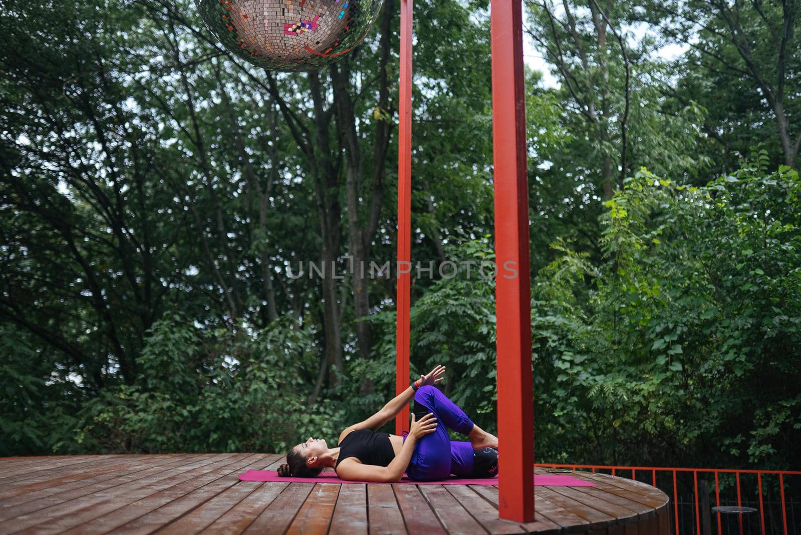 A young woman in doing yoga in the yard on the veranda