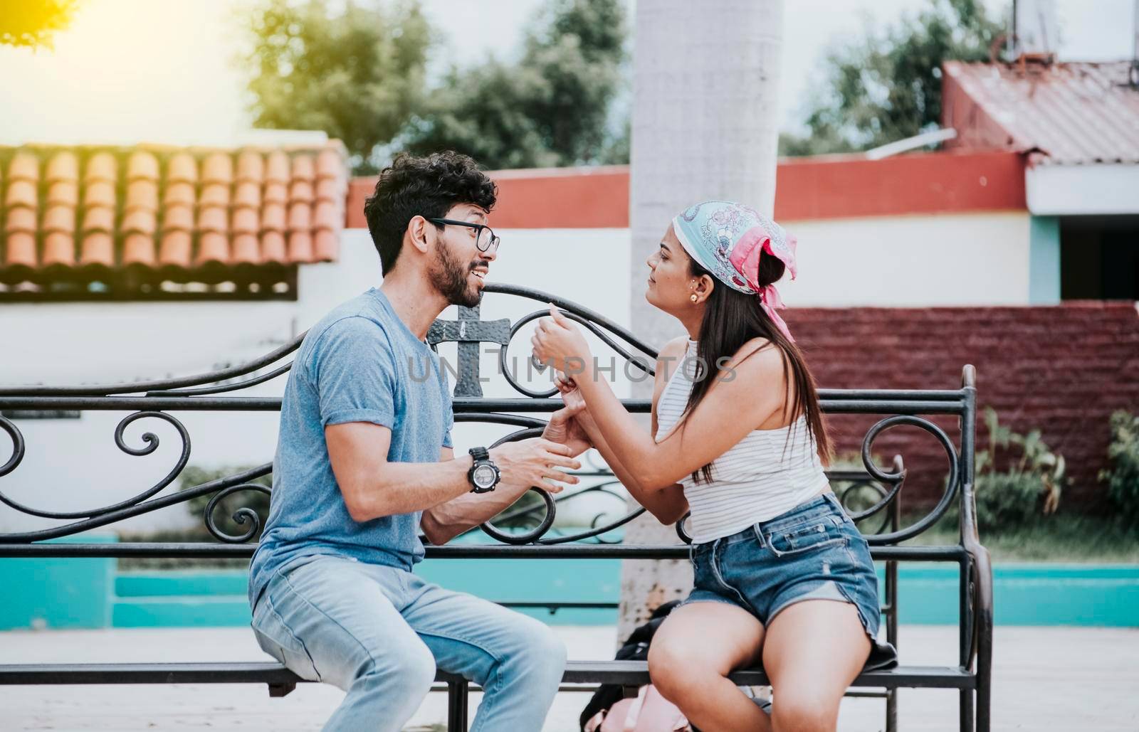 Young couple arguing sitting on a park bench, Concept of aggressive couples in the park. Upset couple arguing on a park bench. Man arguing with his girlfriend sitting in a park