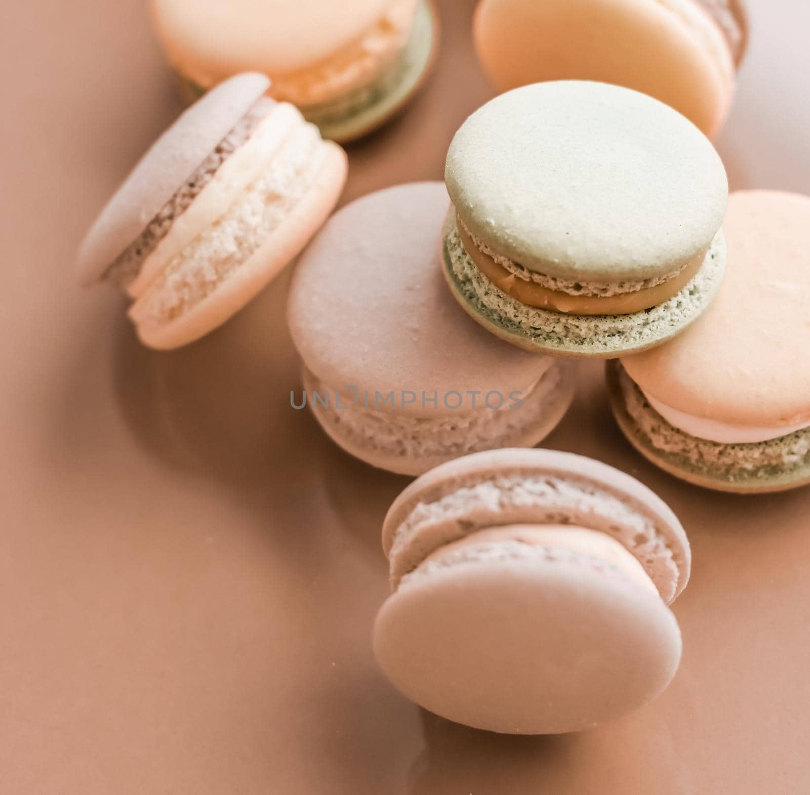 Pastry, bakery and branding concept - French macaroons on cream beige background, parisian chic cafe dessert, sweet food and cake macaron for luxury confectionery brand, holiday backdrop design