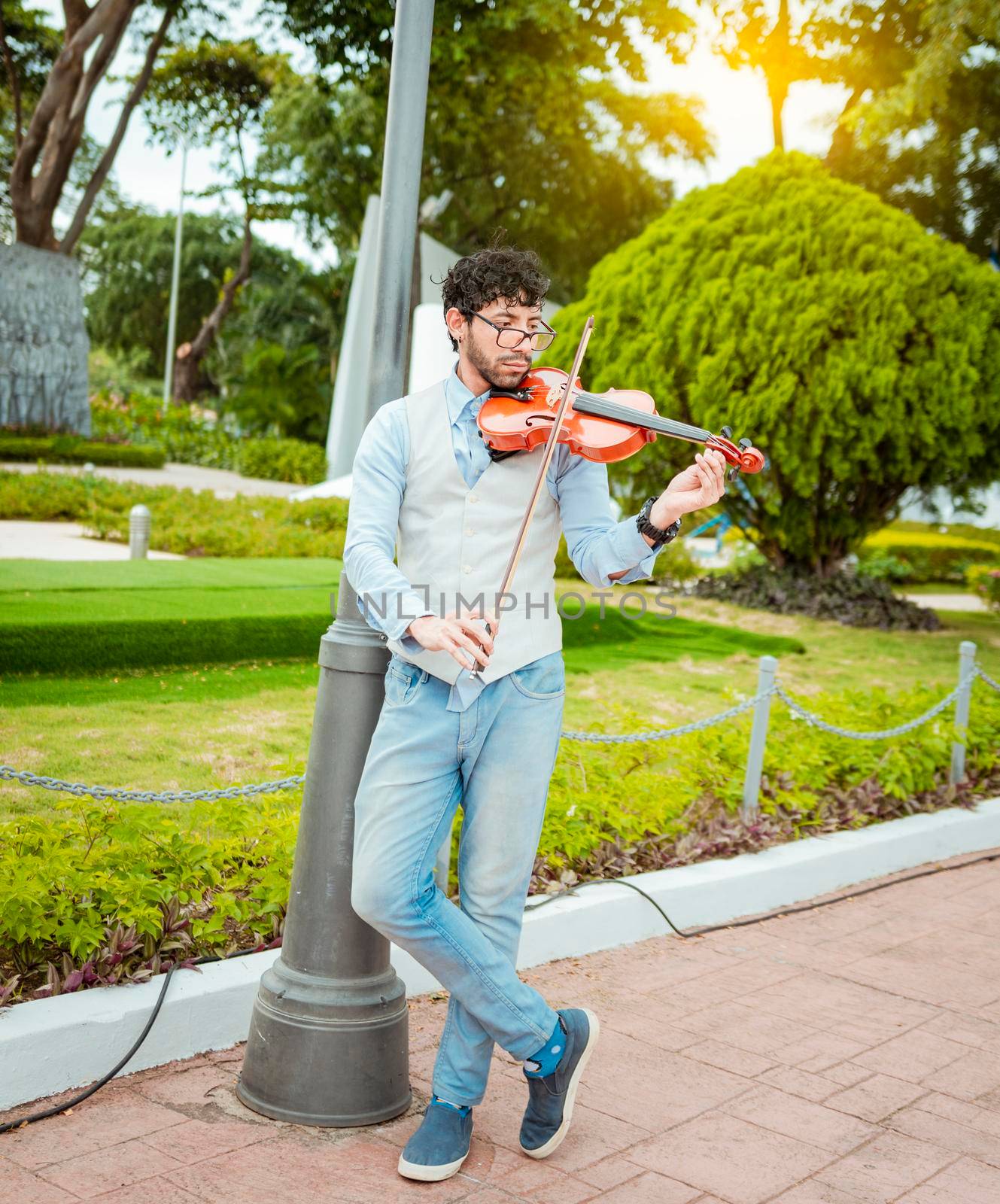 Portrait of man playing violin in the street. Jacket artist playing violin outdoors, Image of a person playing violin outdoors. Man playing violin in the street by isaiphoto