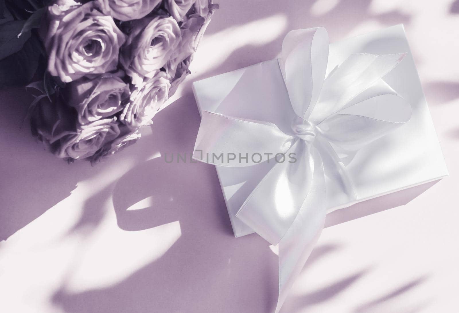 Happy holidays, luxe shopping and love gifts concept - Luxury holiday silk gift box and bouquet of roses on purple background, romantic surprise and flowers as birthday or Valentines Day present