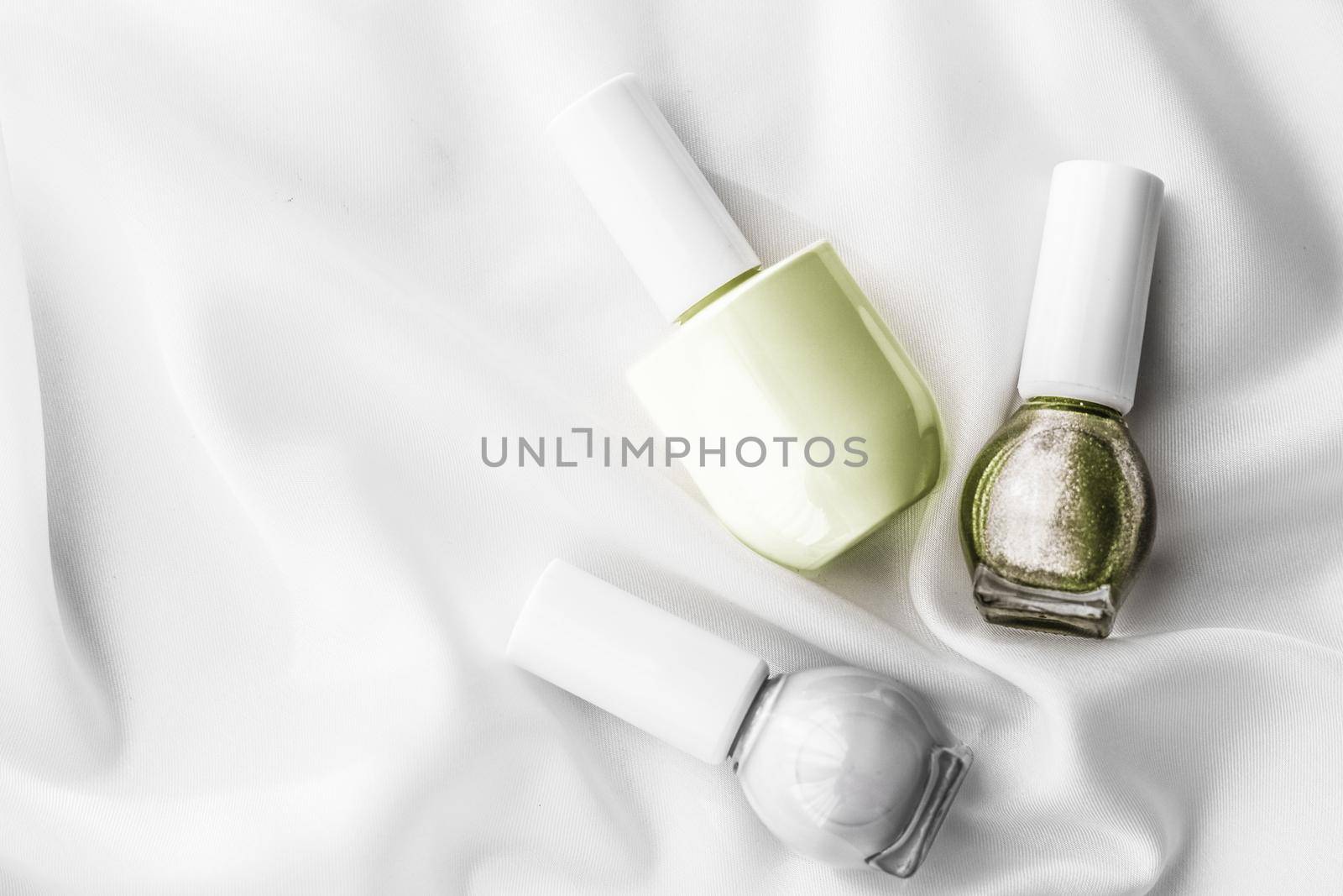 Cosmetic branding, salon and glamour concept - Nail polish bottles on silk background, french manicure products and nailpolish make-up cosmetics for luxury beauty brand and holiday flatlay art design