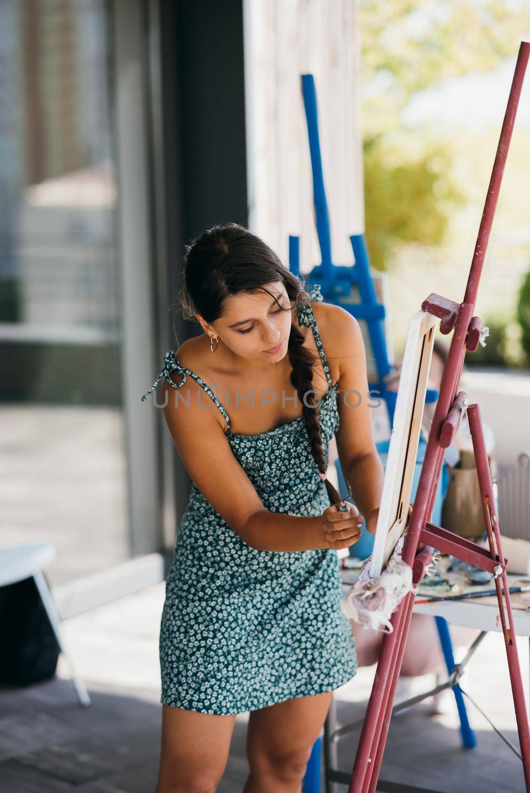 Female artist painting picture in workshop