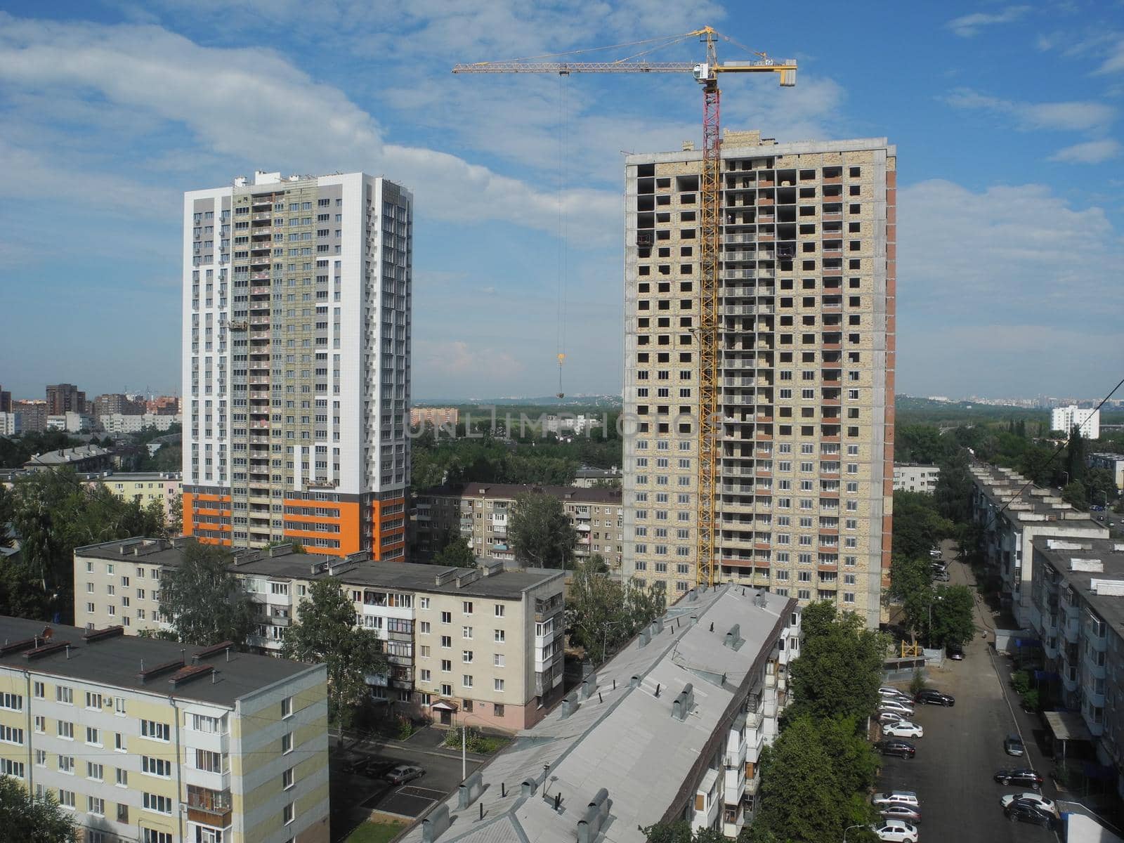 Crane and building under construction against blue sky.